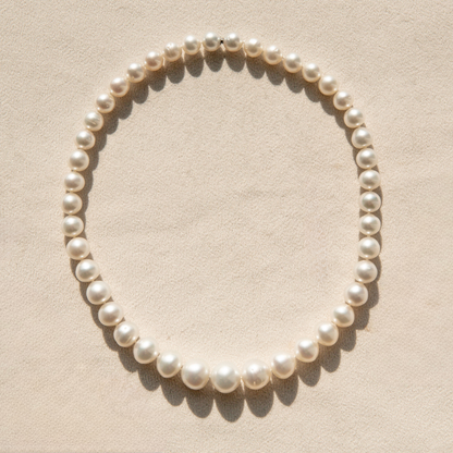 Pearl strand necklace on a beige background