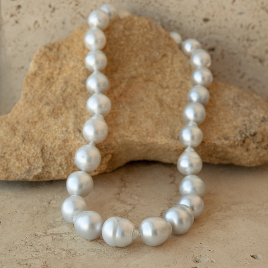 Pearl strand necklace on a textured stone surface