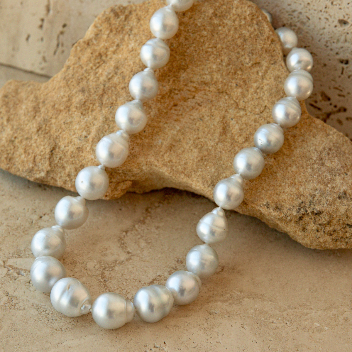 Pearl strand necklace on a textured stone surface