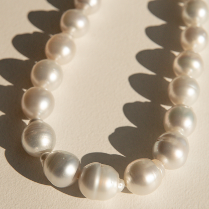 Pearl strand necklace on a beige background