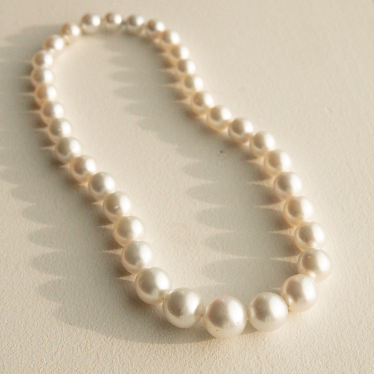 Round pearl strand necklace on a light background