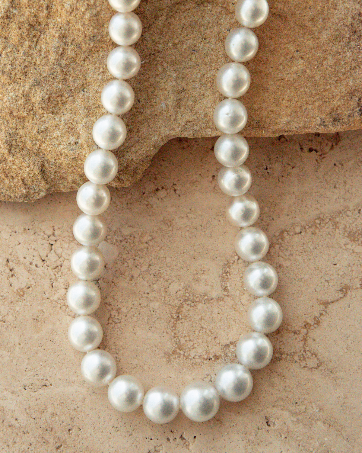 Pearl necklace on a textured stone surface
