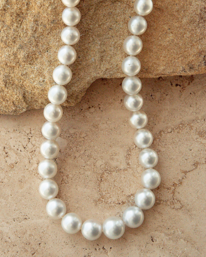 Pearl necklace on a textured stone surface