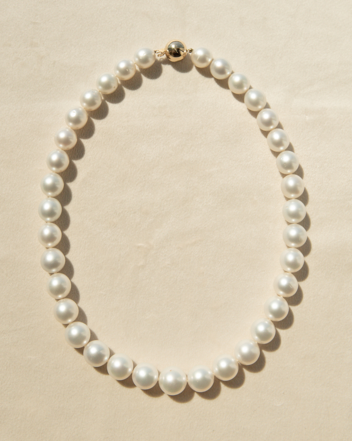 Pearl necklace on a beige background