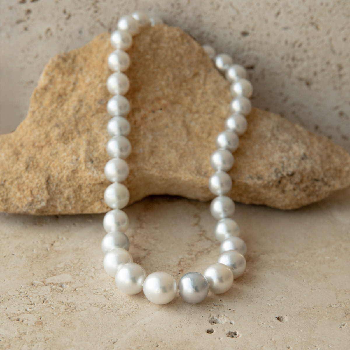 Pearl strand necklace on a textured stone surface