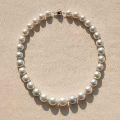 Pearl strand necklace on a beige background