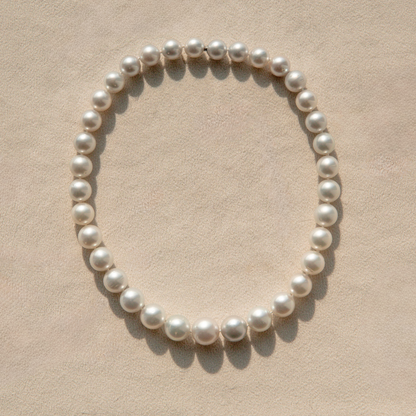 Pearl strand necklace on a beige background