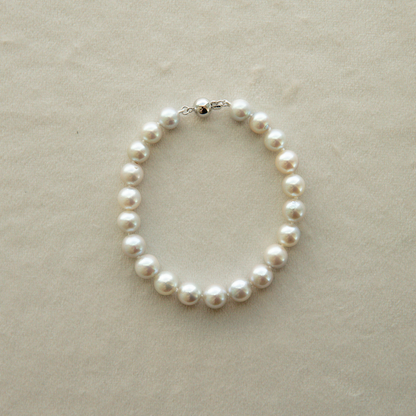 Pearl strand bracelet on a beige background