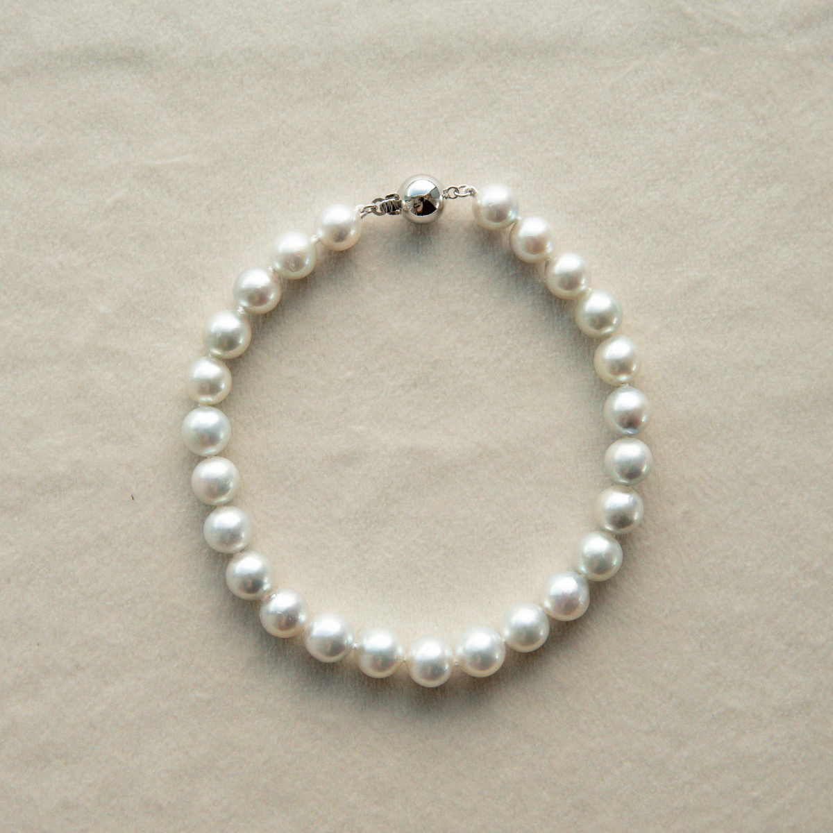Pearl strand necklace on a beige background