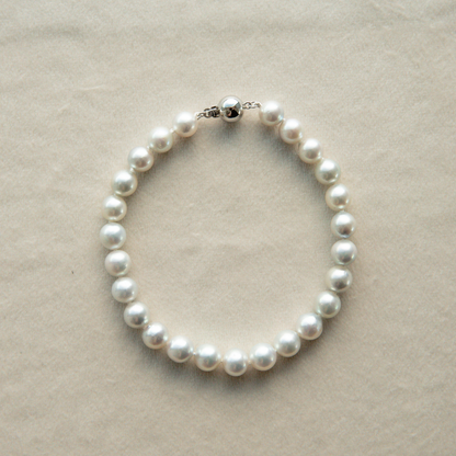Pearl strand necklace on a beige background