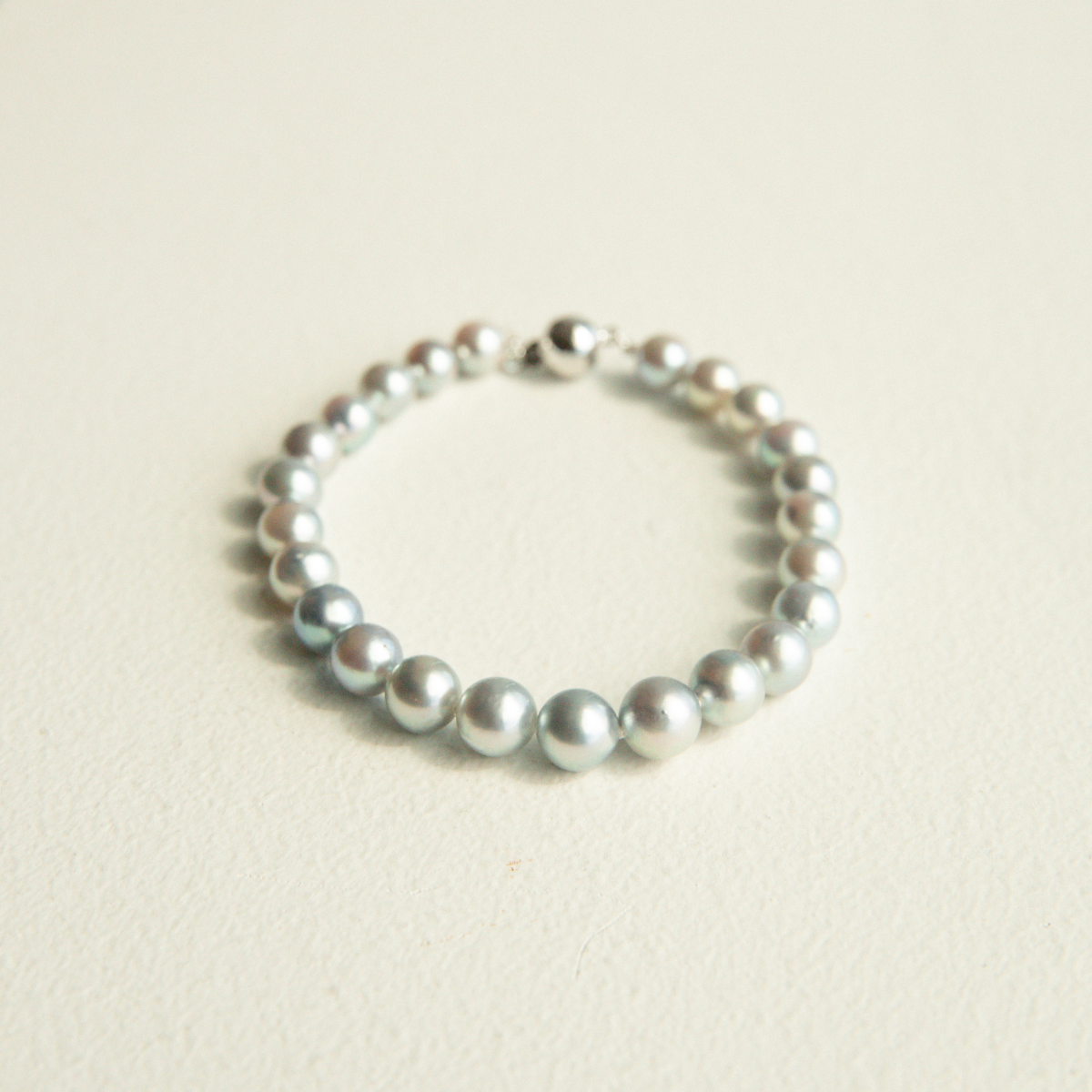 Pearl strand bracelet on a light beige background