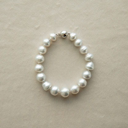 Pearl strand bracelet on a beige background