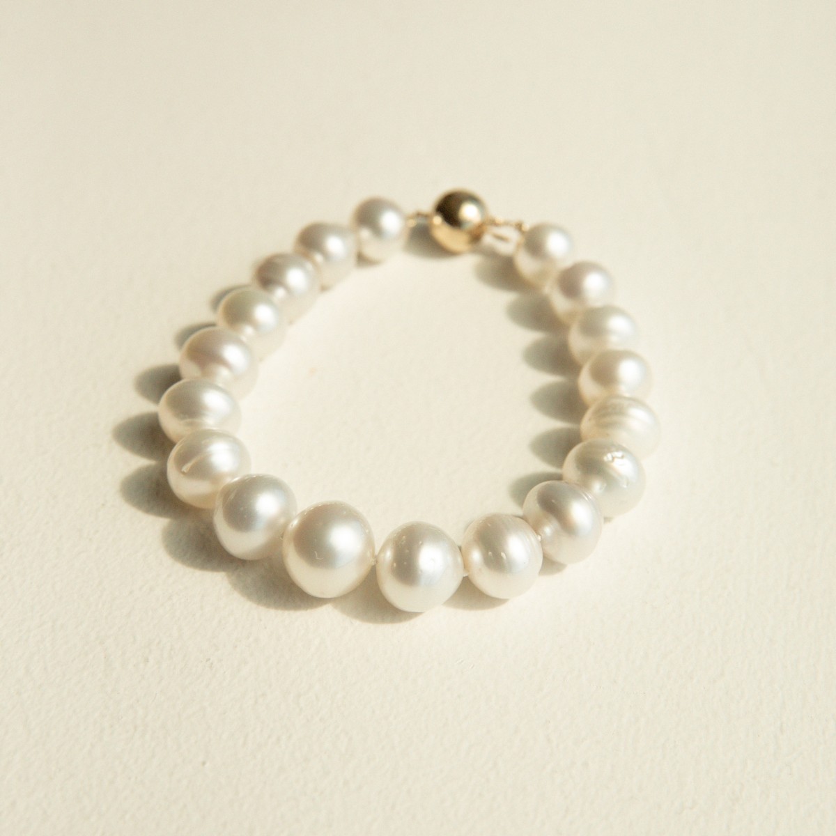 Pearl strand bracelet on a beige background