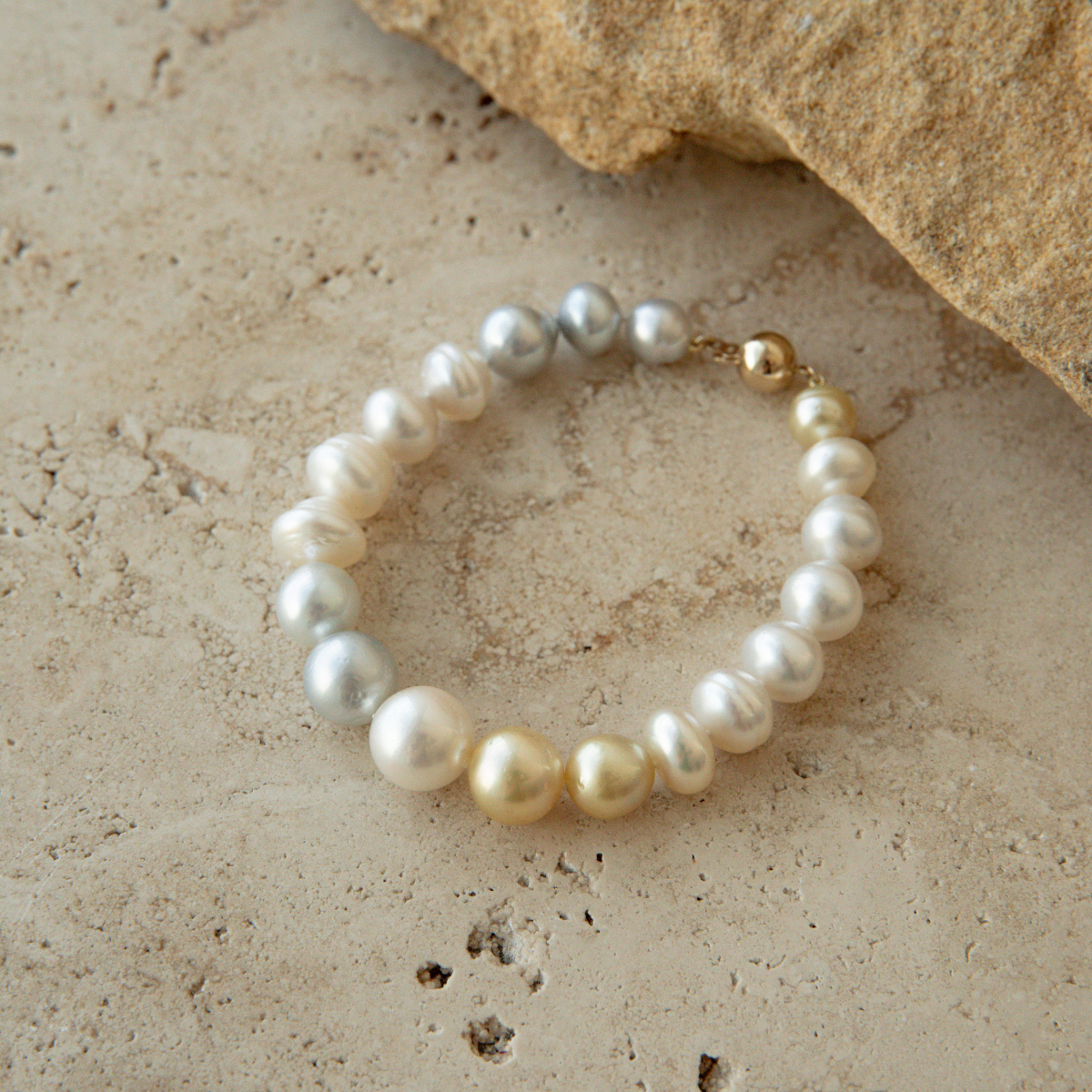 Pearl strand bracelet on a textured stone surface