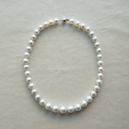 Pearl strand necklace on a light gray background