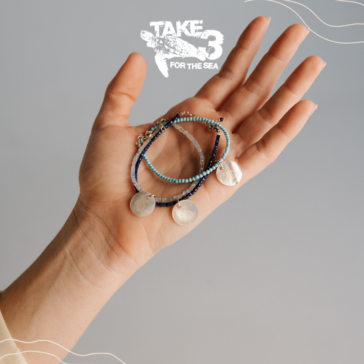 Hand holding three bracelets with 'Take 3 for the Sea' logo in the corner