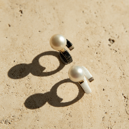 Two black and white ceramic rings with stunning South Sea pearls, set on a stone.