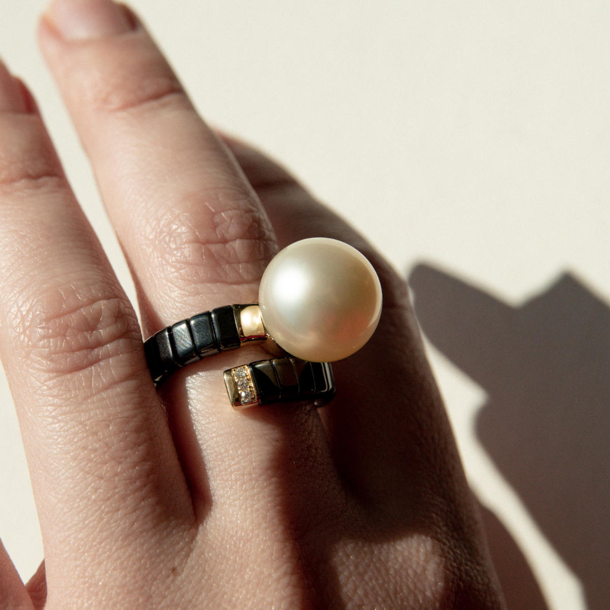Black ceramic ring with stunning South Sea pearl, worn by someone.