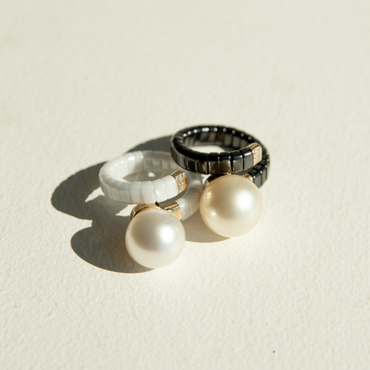 Two ceramic rings, set with stunning Australian South Sea pearls, set alongside white sparking diamonds.