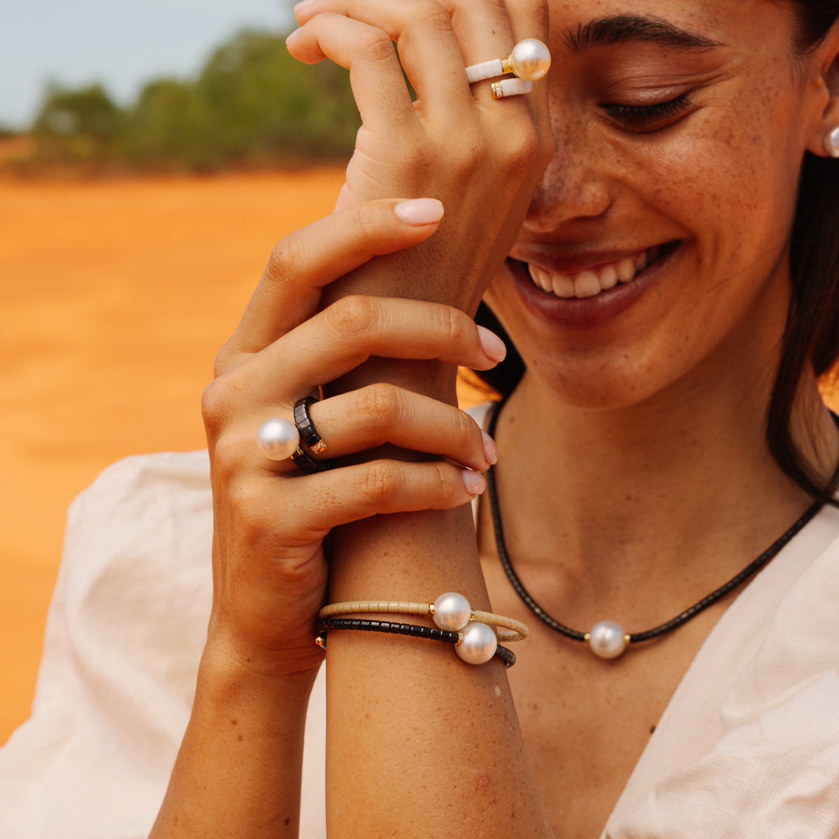 Woman with pearl jewelry against a desert background