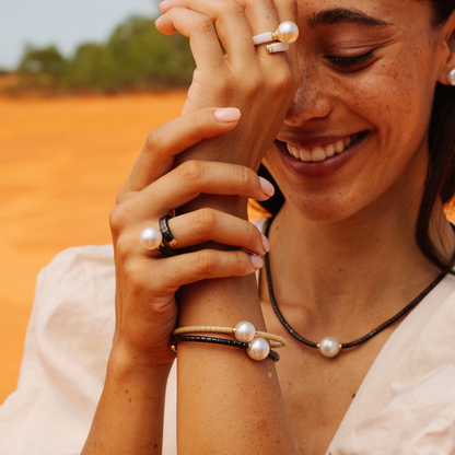 Woman with pearl jewelry against a desert background