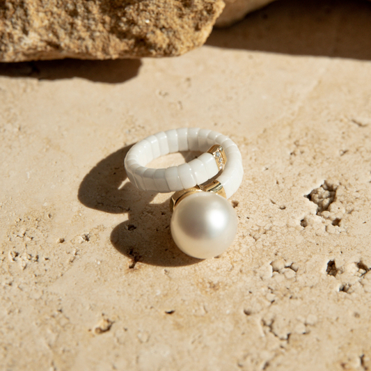 Ceramic & Pearl ring on a textured stone surface.