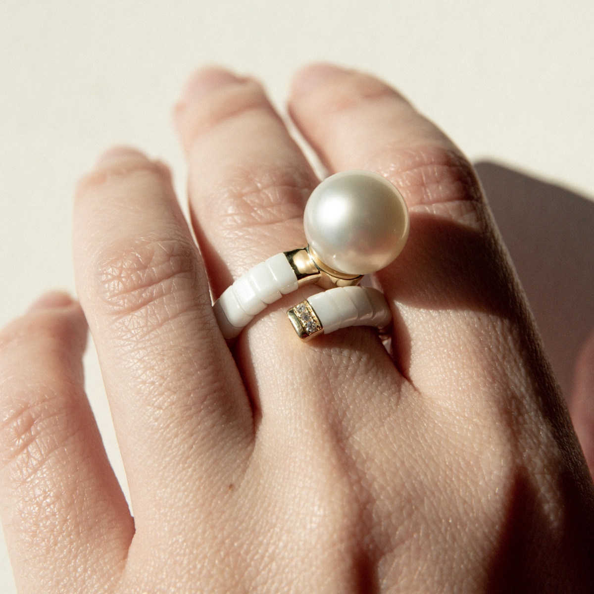 Ceramic & Pearl ring on a textured stone surface.Ceramic & Pearl ring worn on someone's finger