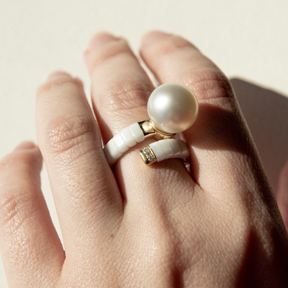 Ceramic & Pearl ring on a textured stone surface.Ceramic & Pearl ring worn on someone's finger