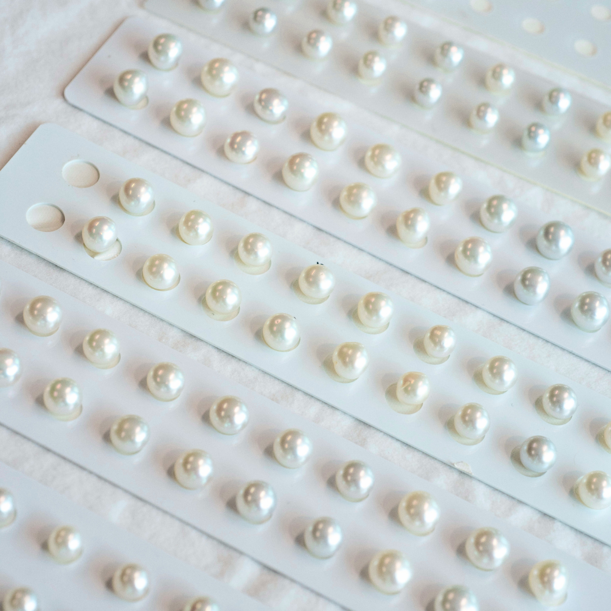 An array of pearl graded and matched Australian South Sea pearls set on pairing cards to be made into stunning pearl earrings. 