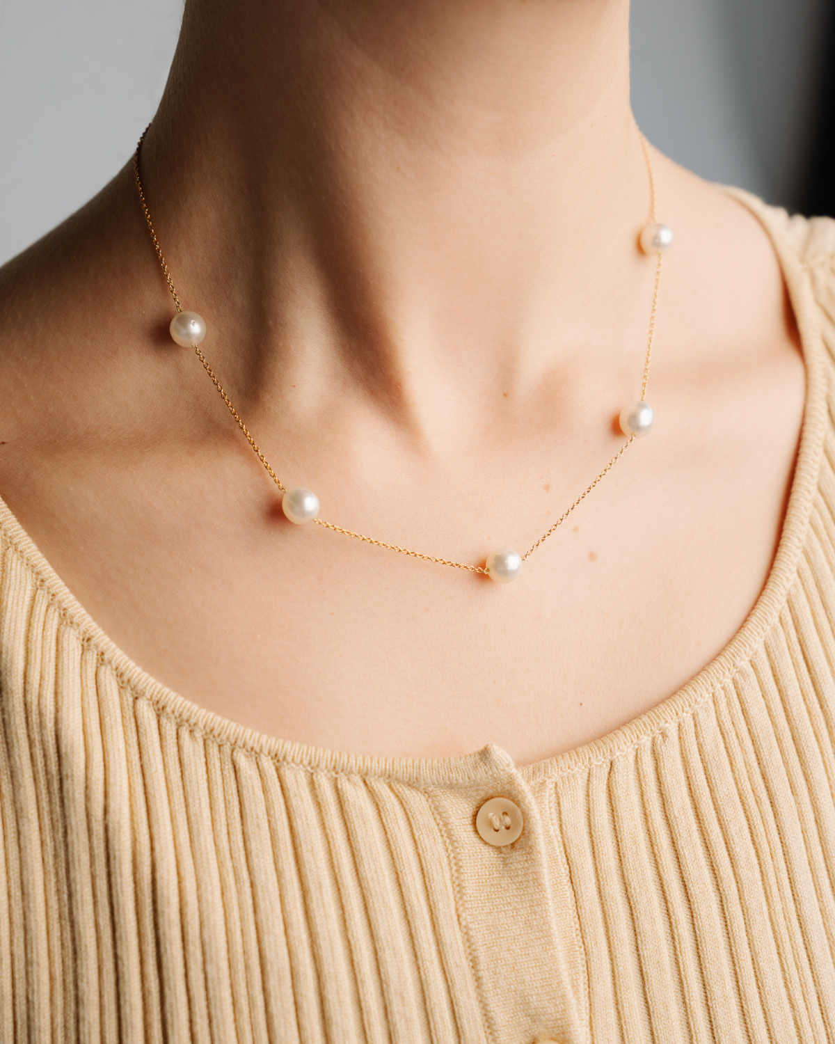 Pearl necklace featuring Australian South Sea pearls set on a solid gold chain worn by a person on a plain background, comfortable and hypoallergenic.