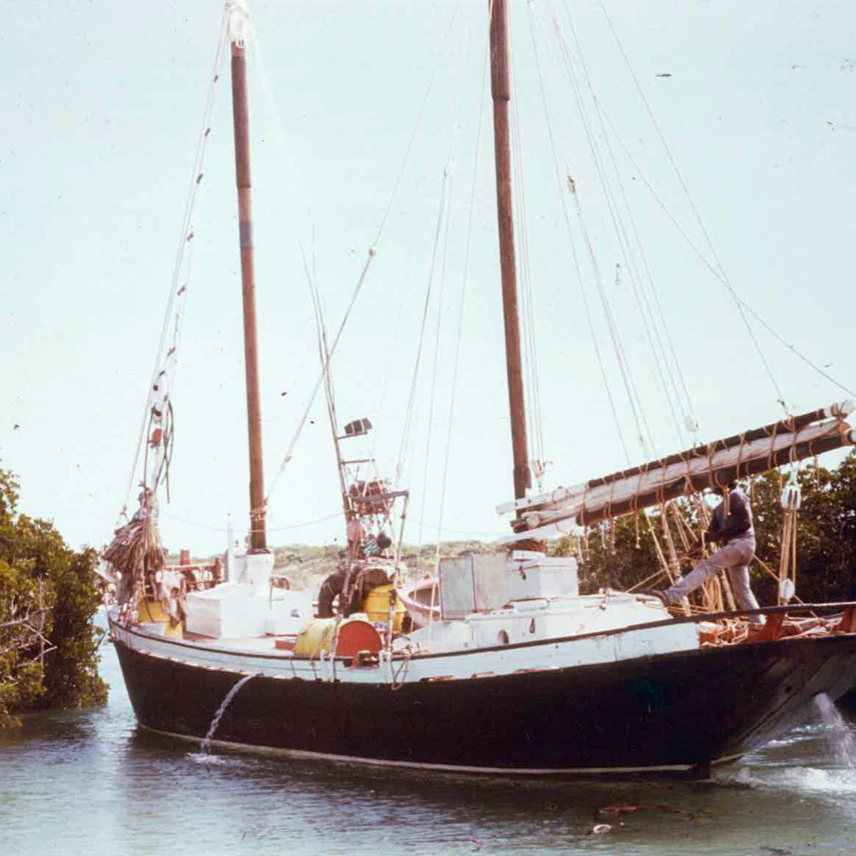The Cygnet Bay Pearl lugger boat on water at Diver's Creek - at Cygnet Bay Pearl farm with trees in the background.