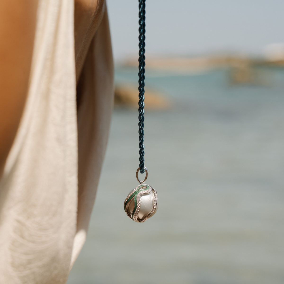 Necklace with a South Sea pearl pendant hanging from a blurred natural background