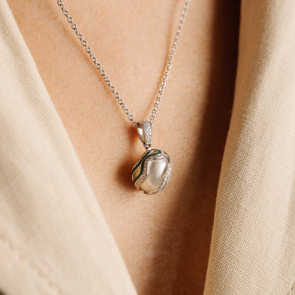 Pearl pendant necklace on a person wearing a beige top