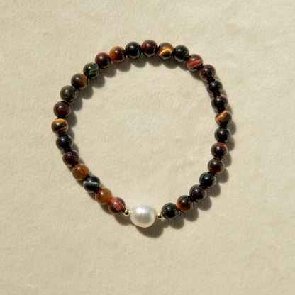 Tiger eye beaded bracelet with a pearl on a beige background