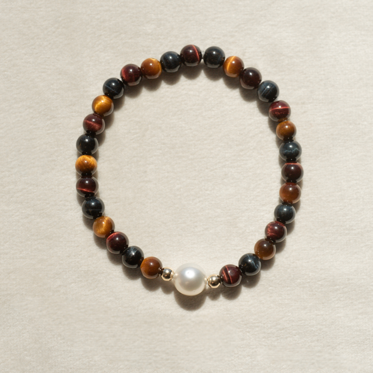 Featuring a luminous Cygnet Bay (WA) grown 8.5mm Near Round B1 grade Australian South Sea pearl nestled alongside 30 tiger's eye beads and two 9ct yellow gold rondels