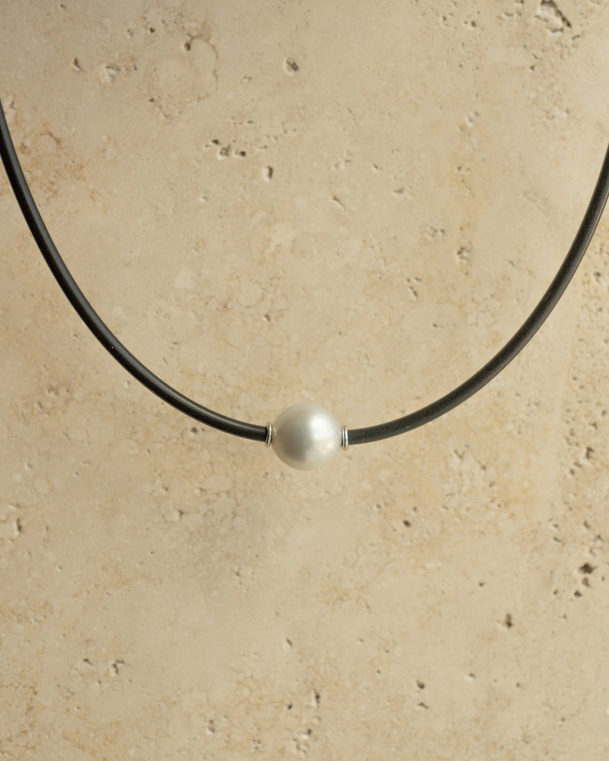 A gorgeous Australian South Sea pearl set alongside two white gold rondels on a neoprene necklace.