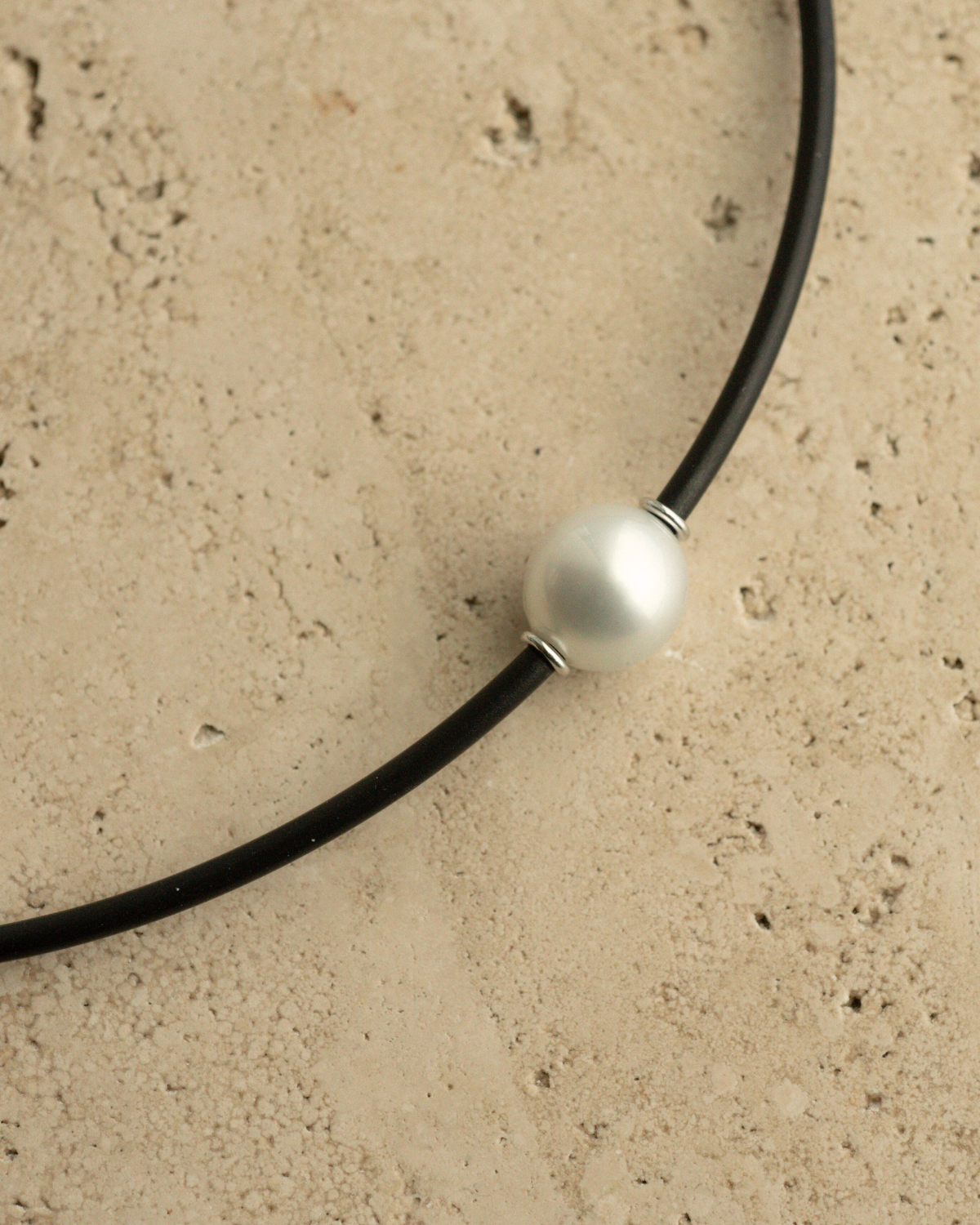 A gorgeous Australian South Sea pearl set alongside two white gold rondels on a neoprene necklace.