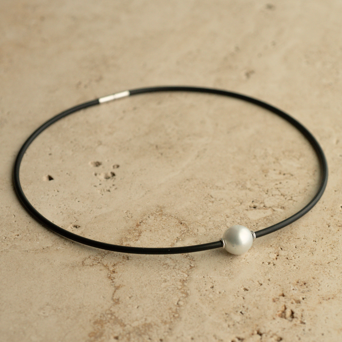 A gorgeous Australian South Sea pearl set alongside two white gold rondels on a neoprene necklace.