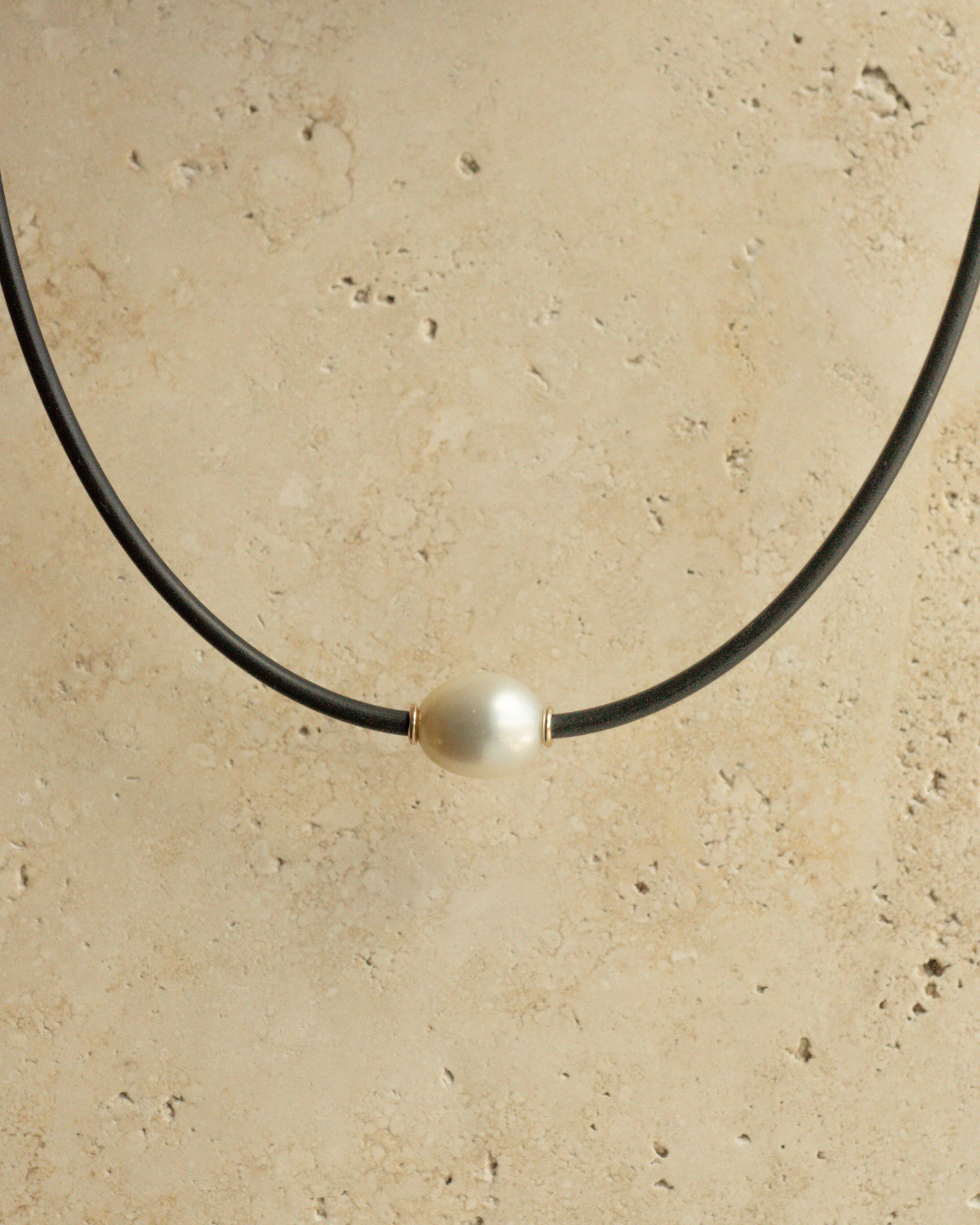 A gorgeous Australian South Sea pearl set alongside two yellow gold rondels on a neoprene necklace.