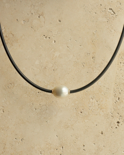 A gorgeous Australian South Sea pearl set alongside two yellow gold rondels on a neoprene necklace.