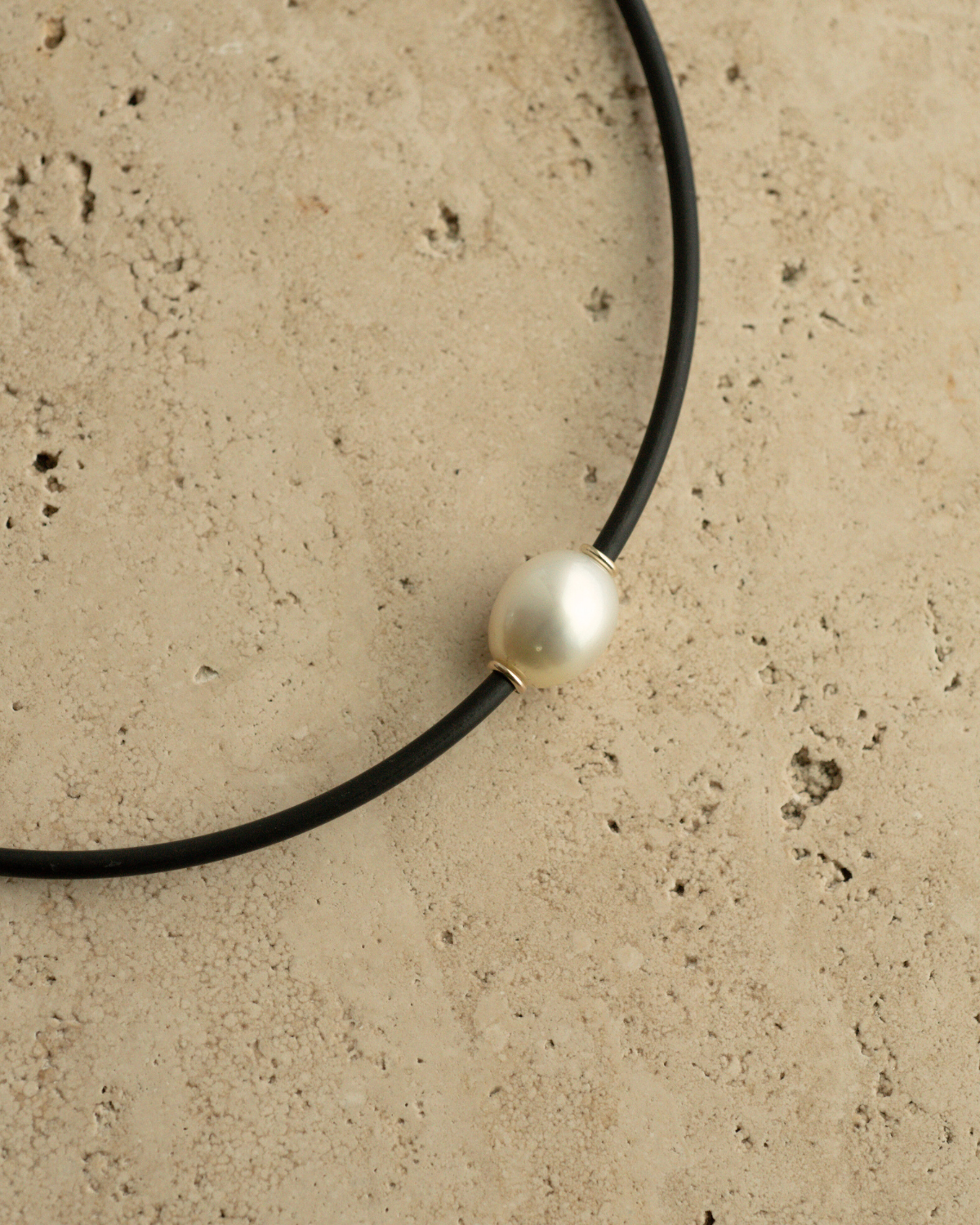 A gorgeous Australian South Sea pearl set alongside two yellow gold rondels on a neoprene necklace.