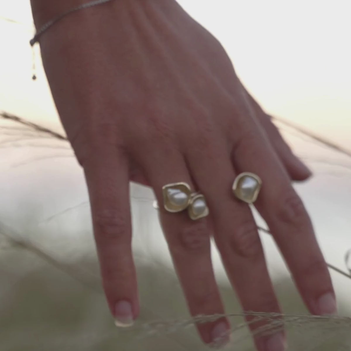 A woman wears her Kimberley Lily Float Ring that features Cygnet Bay grown Keshi pearls set in solid gold organic shape designs. 