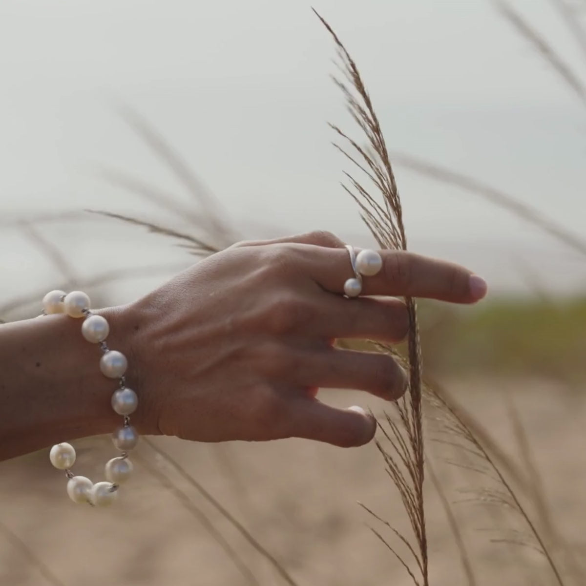 A woman wears her Provenance Twist Pearl Ring featuring our Australian grown South Sea and Akoya pearls set alongside one another - a true Australian treasure.