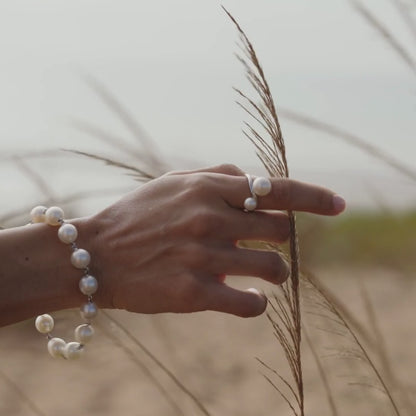A woman wears her Provenance Twist Pearl Ring featuring our Australian grown South Sea and Akoya pearls set alongside one another - a true Australian treasure.