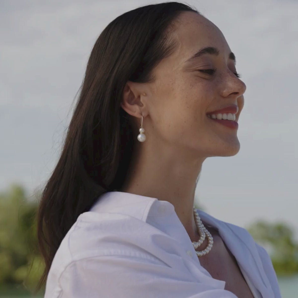 A woman wears her timeless Eternal Diamond Hook Earrings that feature our Australian grown South Sea and Akoya pearls.