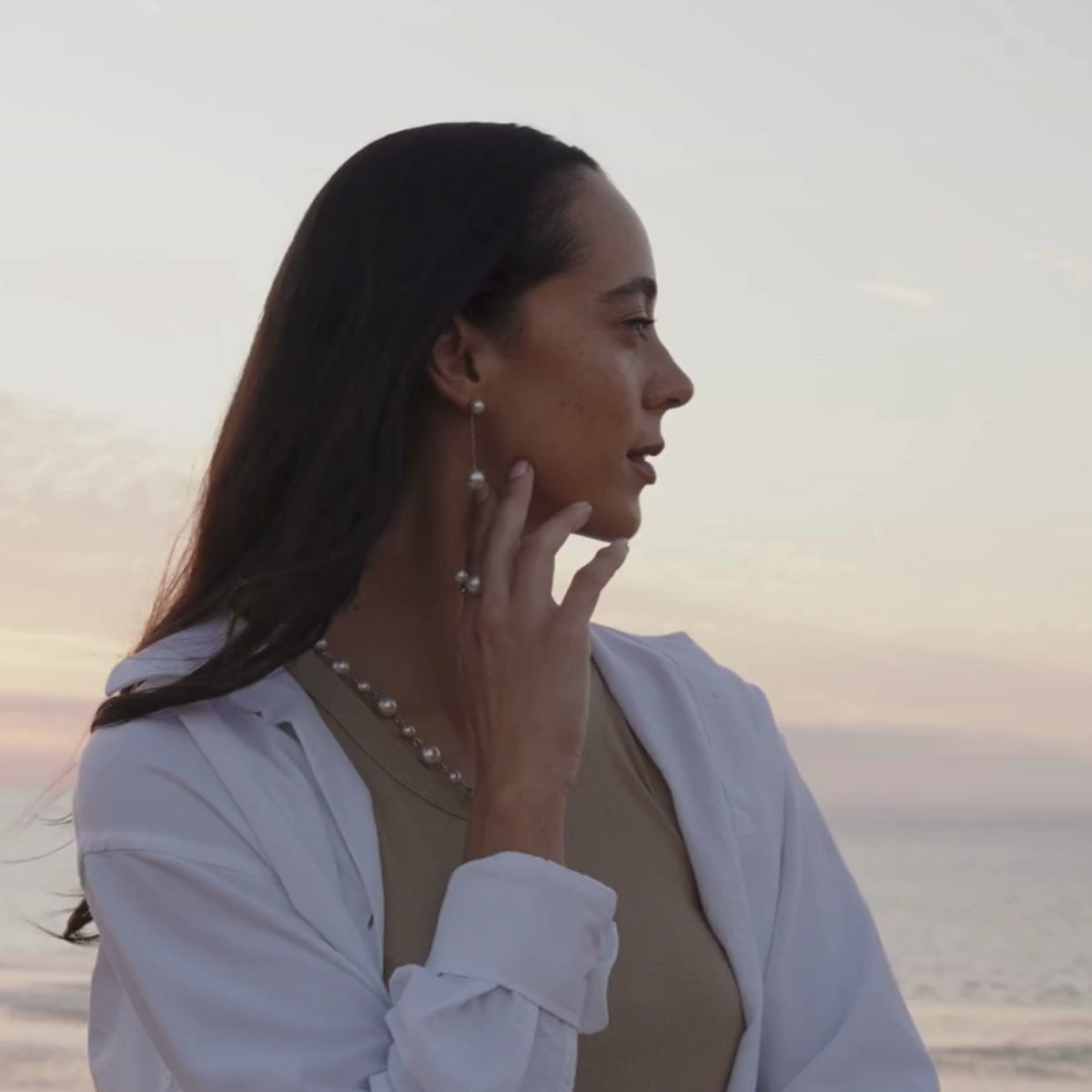 A woman wears her timeless Provenance Long Pearl Earrings that feature a detachable South Sea pearl earring enhancer that attaches to a pair of stunning Akoya pearl studs. Both pearl types are grown at our very own Cygnet Bay and Broken Bay pearl farms in Australia.