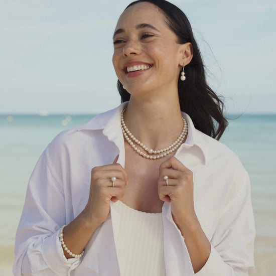 A woman wears her Eternal Diamond Pearl Jewellery pieces, including a pair of hooks, pearl strand necklaces, a pearl strand bracelet and pearl rings all featuring our Australian grown South Sea and Akoya pearls set alongside stunning white diamonds.