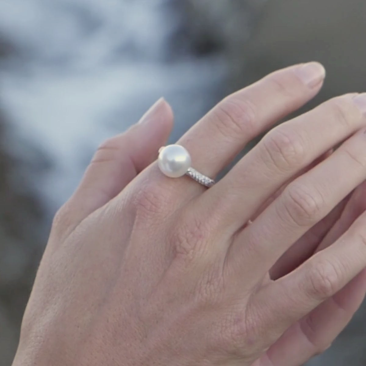 Woman wears a stunning Stella Petite Pearl Ring that features a large, white, round South Sea pearl grown at Cygnet Bay Pearl Farm set with stunning white sparkling diamonds on the ring's band.