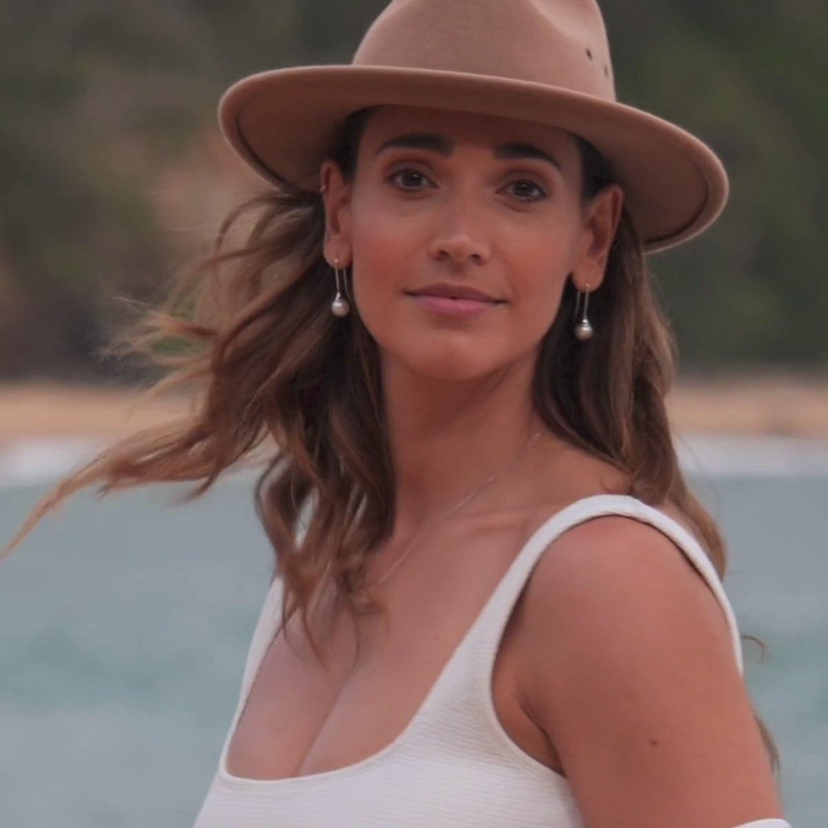 A woman wears her Inca Pearl Hooks that feature Cygnet Bay grown South Sea pearls that are large, white and round set in solid gold. 