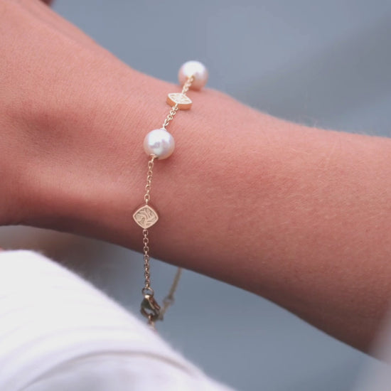 A woman wears her Seagrass Akoya Pearl bracelet that features Broken Bay grown Australian Akoya pearls set on a solidgold chain with seagrass motifs set on the chain.